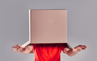 Persona che cerca di orientarsi con scatola in testa