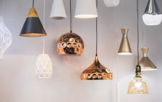 Vista su varie lampade moderne a sospensione color rame, ottone e bianche